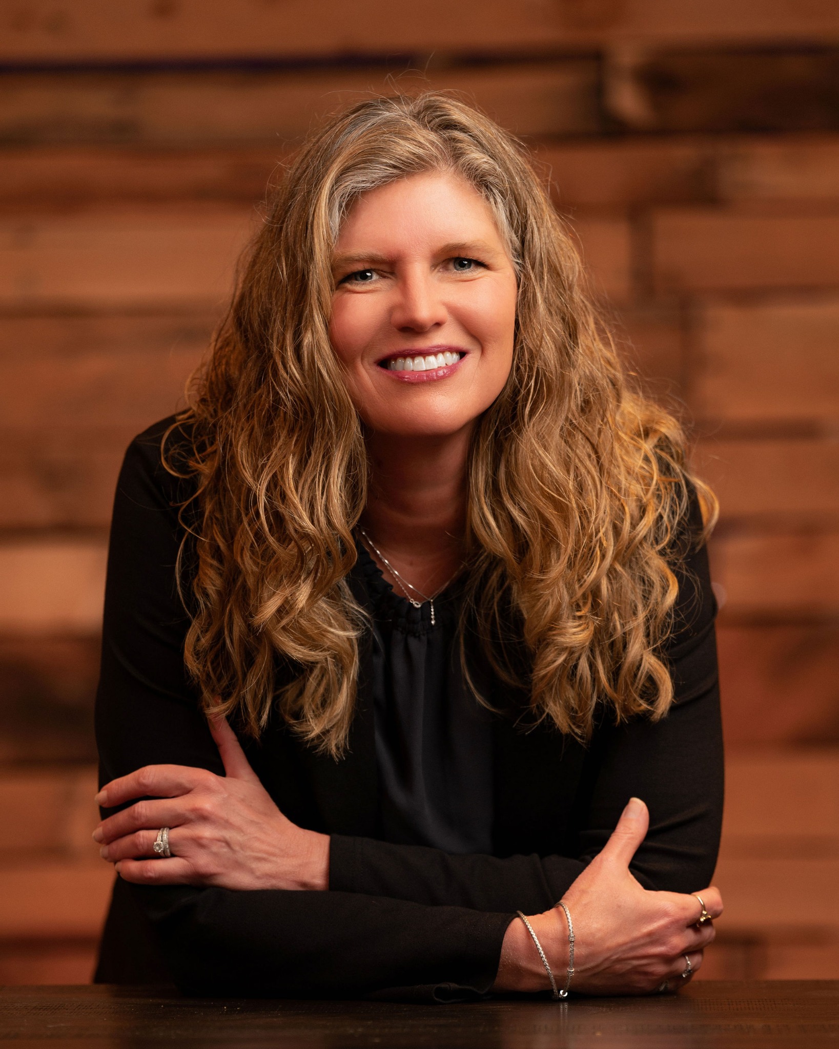 Andrea Danes smiling in a warm professional portrait
